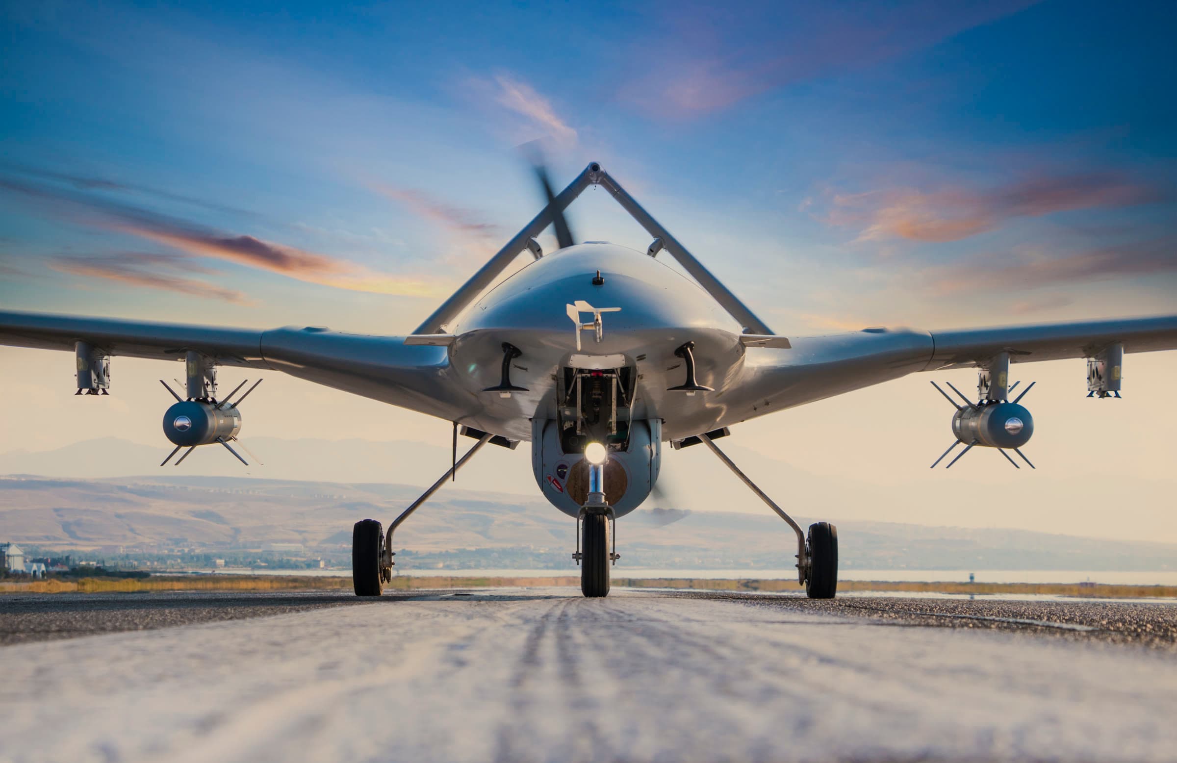 Autonomous military drone on a runway at dusk