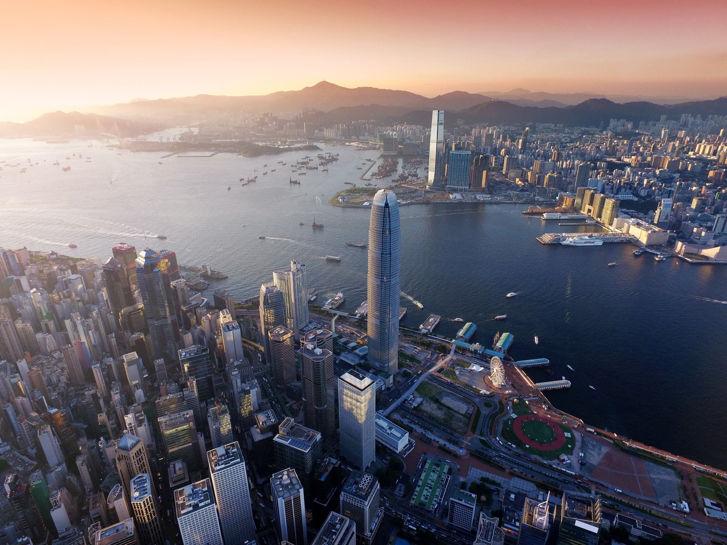 Aerial view of a global financial-center skyline at sunset